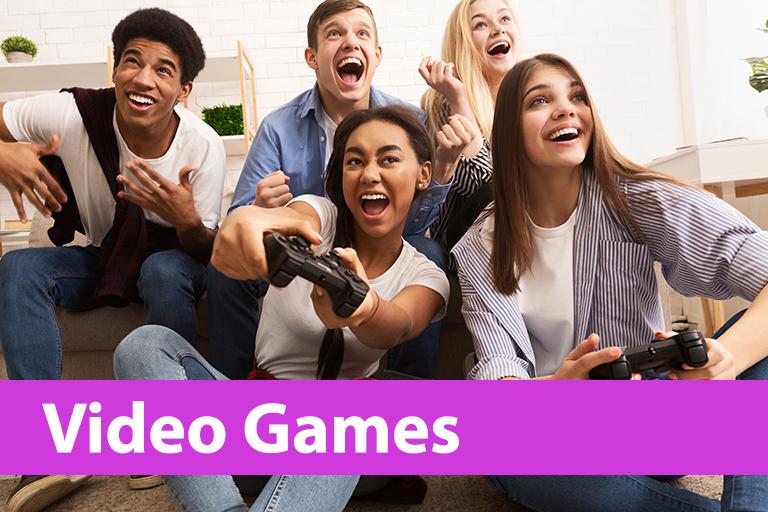 five, smiling teens sitting together with two girls playing a video game