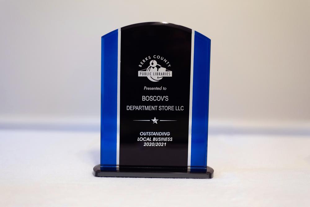 standing, blue-striped, glass plaque with local business award winner information engraved