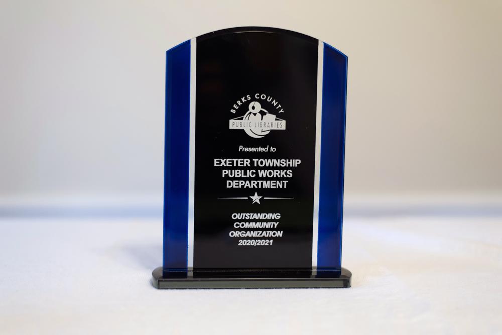 standing, blue-striped, glass plaque with Community Organization award winner information engraved
