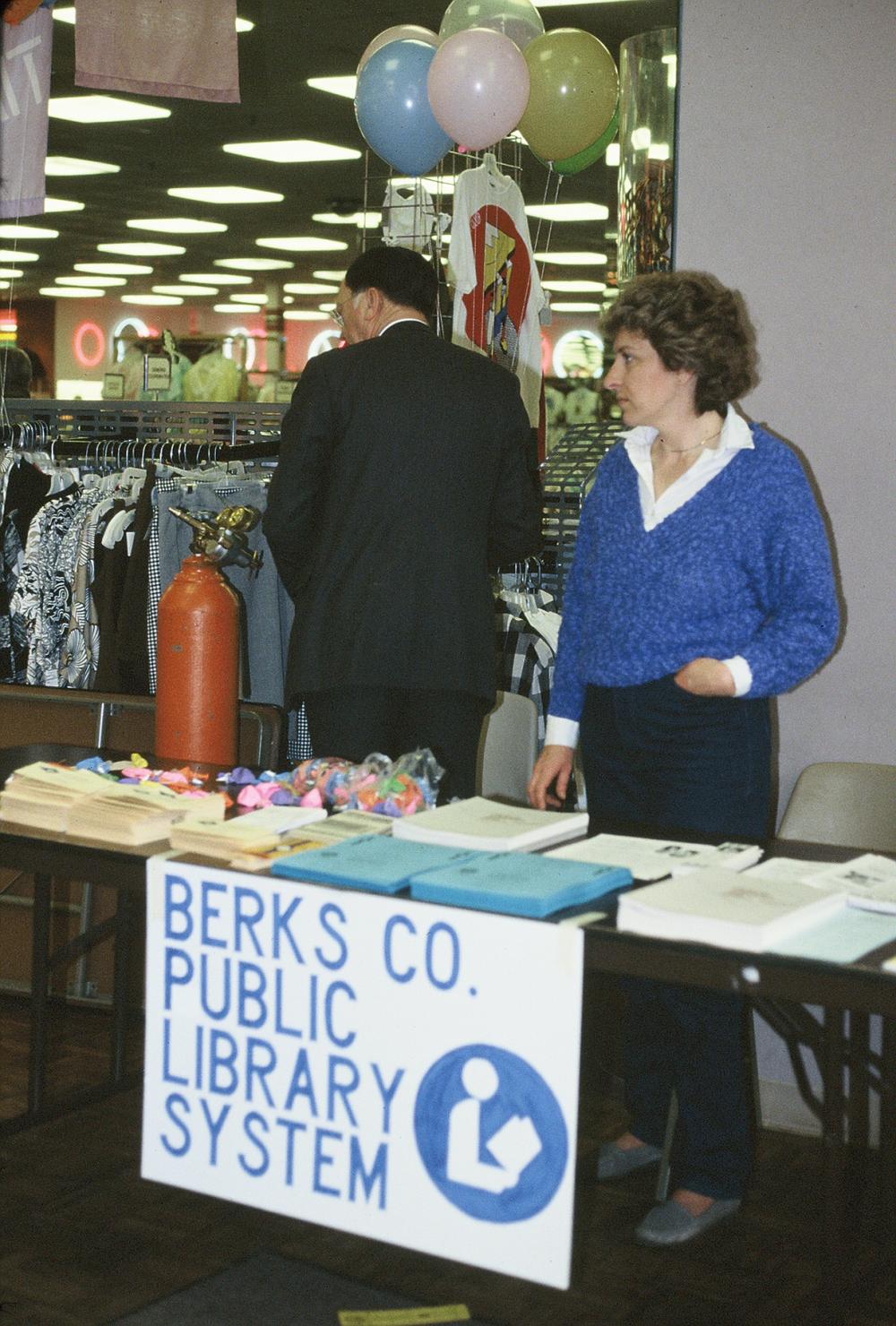 Old photo of Berks County Public Libraries staff member at booth