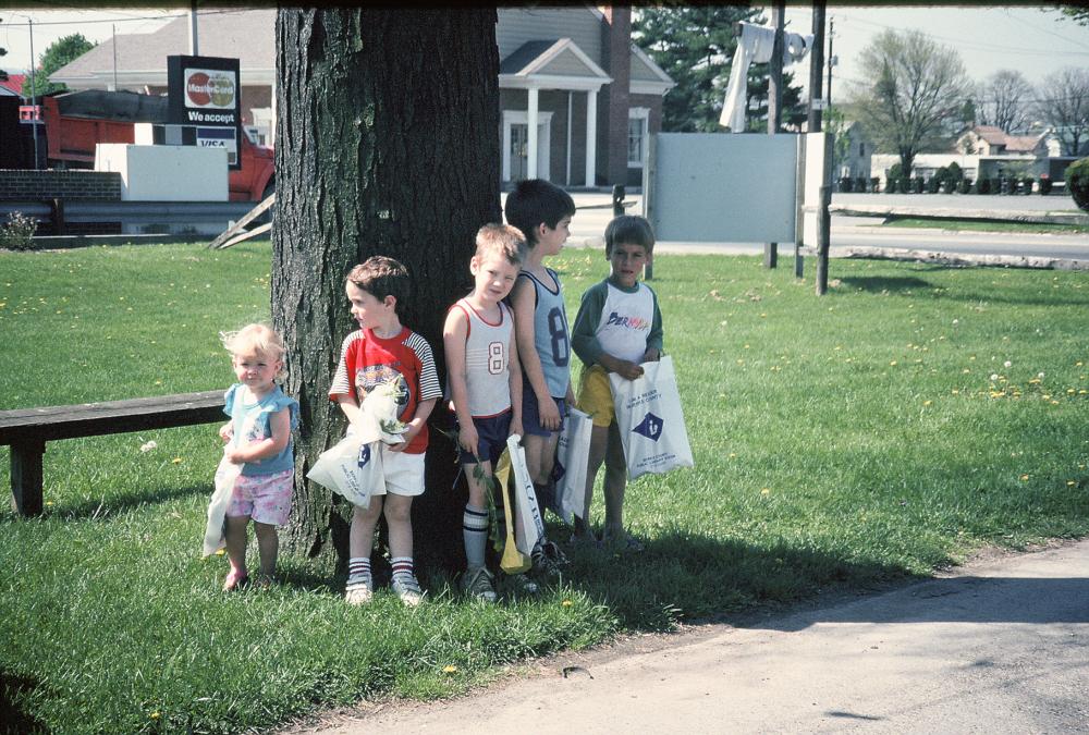 Old photo of kids standing under tree with library prize bags