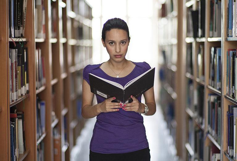 Woman reading in the stacks.