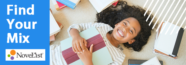 Smiling, young girl laying down with book in her arms