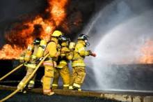 firefighters fighting a fire with a firehose
